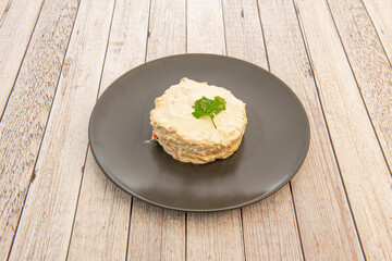Portion of Russian salad with mayonnaise and parsley, peppers, carrots, potatoes and coddled egg