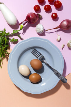 Eggs on plate against red onions and white eggplant