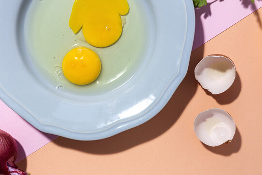 Fresh eggs on plate against red onion