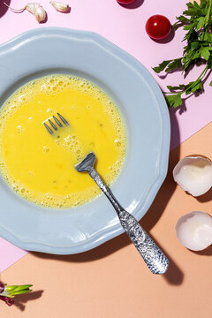 Beaten egg on the plate against ripe parsley