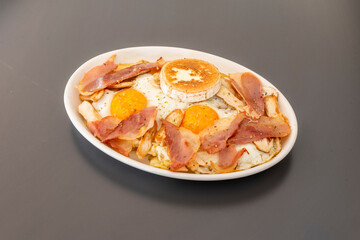 Cracked egg tray with fried bacon, goat cheese and parsley