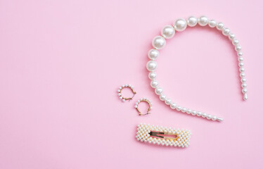 White Pearl Hair clips and earring on pink background, group of trendy accessories. Copy space