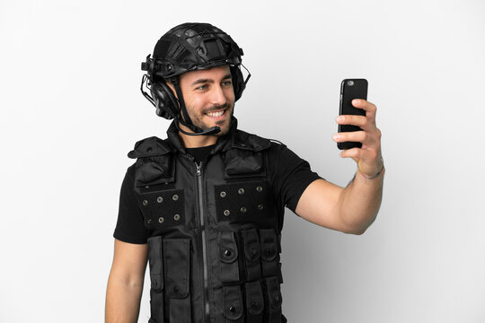 Young caucasian swat isolated on white background making a selfie
