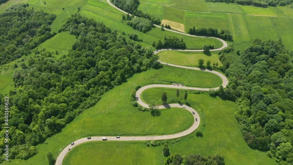 Wall mural Aerial drone view of winding road between green fields - Wall murals