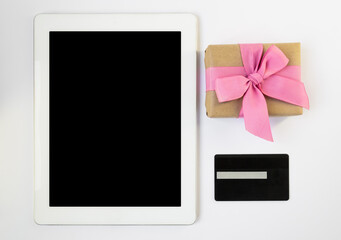 Tablet, bank card and gift wrap. Online shopping. Choosing gifts online