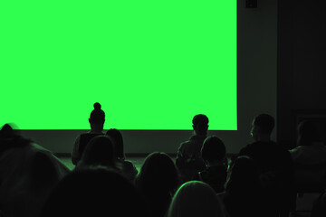 Audience sits in a dark room. Demonstration through a presentation or movie projector. Blank...