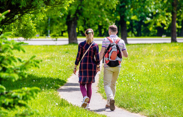 A guy and a girl walk along the path in the city Park
