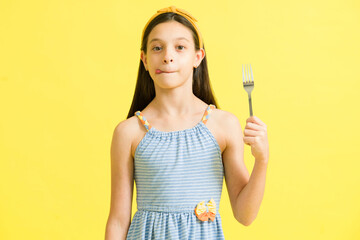 Little girl with cravings holding silverware