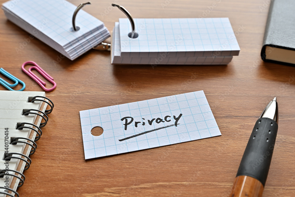 Poster there is a word book with the word privacy written on it with a pen and notebook.