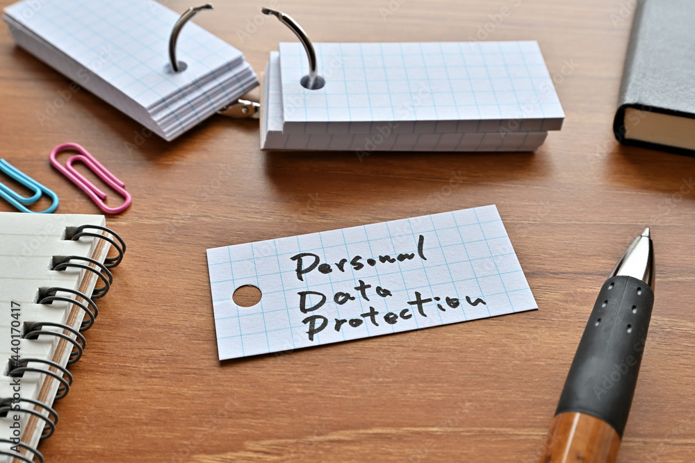 Poster there is a word book with the word personal data protection written on it with a pen and notebook.