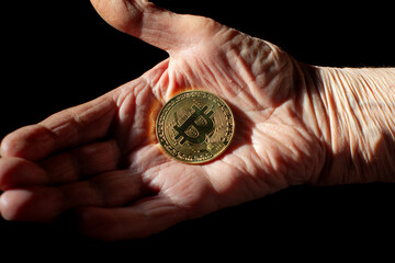 Fototapeta na wymiar bitcoin coin in old woman's hand