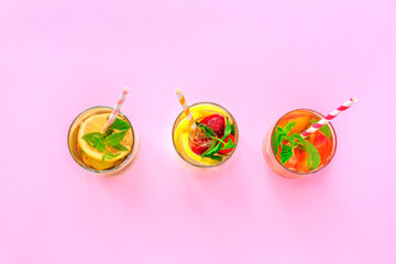Three different colorful cold summer drinks on pink background. Top view, flat lay