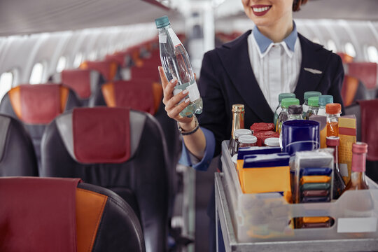 Stewardess Holding Water Bottle In Airplane Cabin