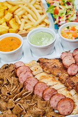 variety of grilled meats and chicken with mayonnaise and sauces