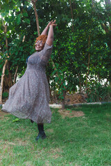 woman in a dress dancing with her hands up