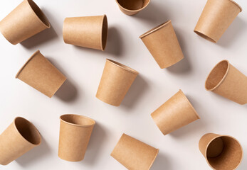 Disposable paper cups on a beige background. Zero-waste concept. View from above.