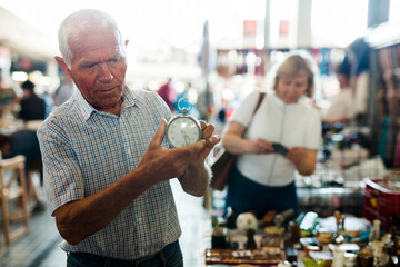 Loving senior family couple choosing vintage things on street market