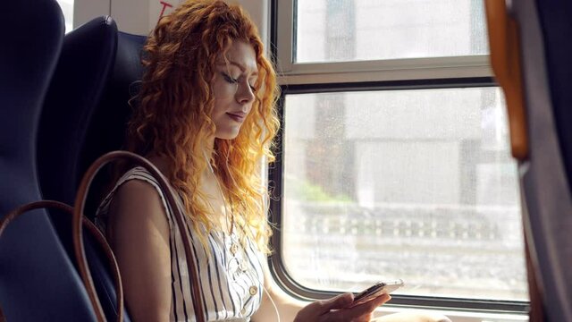 travel, vacation - young woman traveling by train looks out the window