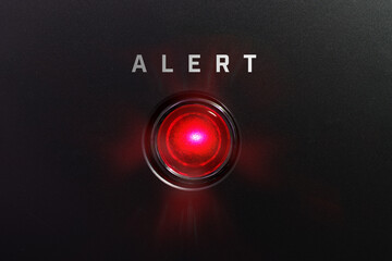 Red glowing warning lamp or button black panel with the words, 