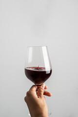 HAND HOLDING WINE GUP ON WHITE BACKGROUND