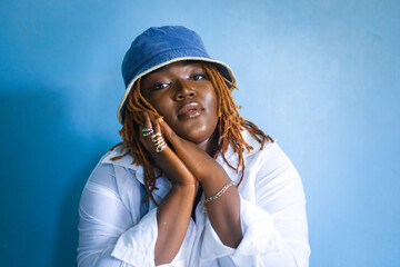 woman posing against a blue wall.