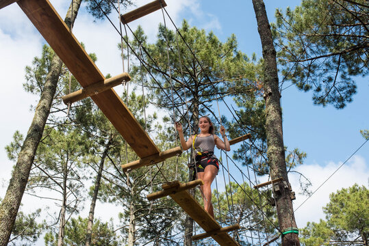 pretty young woman in an extreme tree climbing course - Powered by Adobe