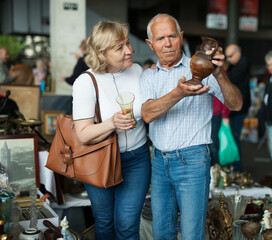 Elderly family choose handmade vase at flea market