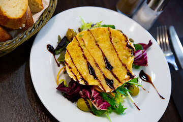 Image of scallop baked with cheese in seashells, served with lettuce and balsamic