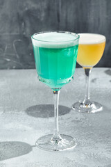 Iceberg cocktail on vintage textured table. Cocktail with vodka and blue curacao liqueur. Summer day and cocktail concept. Sunshine with shadow.