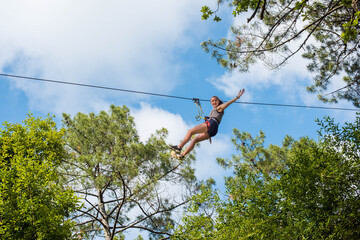 pretty young woman in an extreme tree climbing course