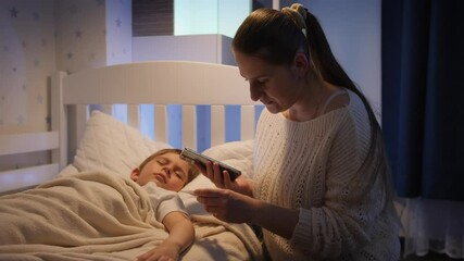 Young worried mother calling doctor by phone at night. Concept of children illness, disease and parent care - Powered by Adobe