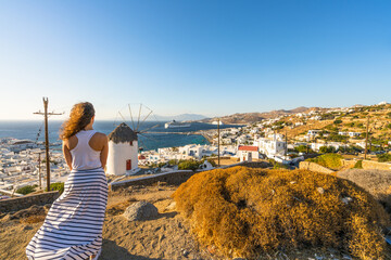 Fototapeta na wymiar Female tourist looking at Mykonos village on Mykons island, Greece