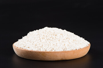 Raw organic white rice on black background, glutinous rice or sticky rice close up