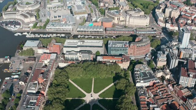 Dolly back pan up drone shot of vibrant central Bristol City UK