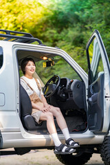 車の運転席に座る若い女性