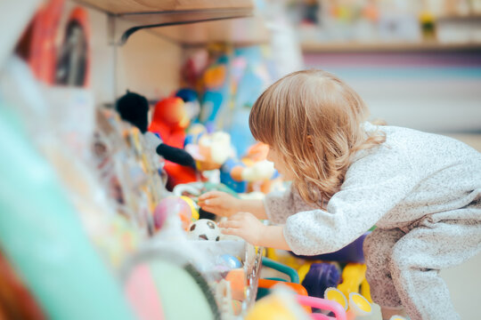 Happy Toddler Girl Choosing a Ball in Toys Store