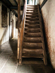 old, grungy, worn out wooden staircase and stone tile floor in an old building in Mumbai, India. © Yojak Vasa