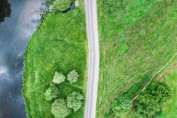 empty bike lane with walking path on riverbank among trees and green grass. drone photo