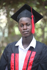 The African American young office gentle business man graduates  takes a head shoot and is straight looking into the camera on his graduation day with a huge smile