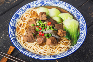 Spicy red soup beef noodle in a bowl on wooden table