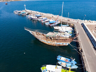 Boats and sea in marina bay in old town Nessebar, Bulgaria. Top view from drone of harbor with yacht, motorboat and sailboat. Aerial view of amazing boats.