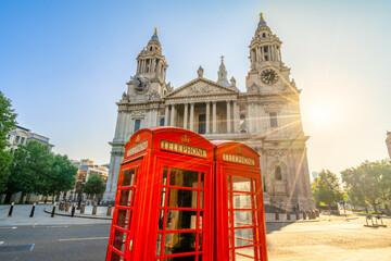 Fototapeta na wymiar Red Telephone booth with sun flare near St Pauls Cathedral in London