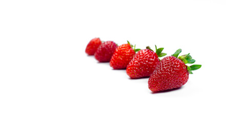 Red fresh strawberry with green tails. Laid out in a row. On white background.