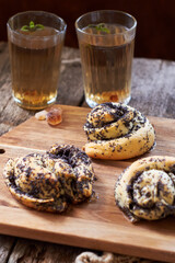 Poppy seed buns. Side view, wooden background. Herbal tea.
