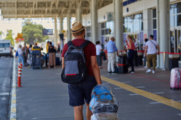 Young man wearing a mask and sealed luggage at the airport. Modern travel concept. High quality photo