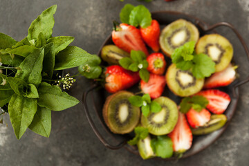 bright and fresh strawberries and kiwi on a dark background