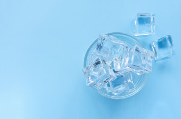 Acrylic ice cubes, Plastic ice cubes in glass on light blue background. 