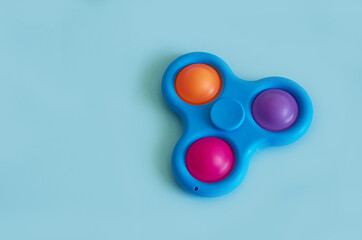  Silicone Toy Spinner Simple Dimple on a blue background. Horizontal format