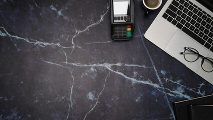 Mock up laptop computer, coffee cup and payment terminal on marble background.
