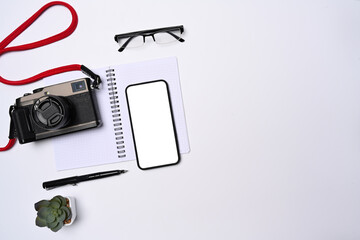 Mock up mobile phone, camera and notebook on photographer workspace.